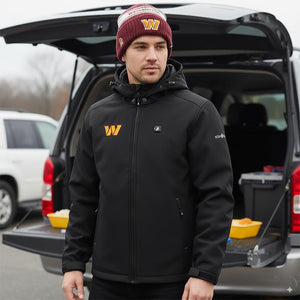 Man wearing a black Washington Commanders heated jacket and a matching knit beanie standing by an open car trunk