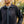 Man wearing a black Aheata zip up jacket with a vertical chest pocket