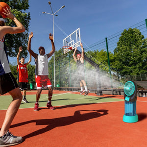 Portable misting fan on a basketball court with players in the background
