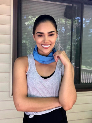 Woman wearing a blue neck gaiter and grey tank top