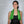Woman wearing a green AlphaCool cooling towel with text overlays explaining product benefits
