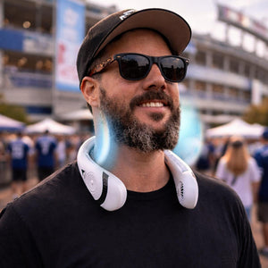 Man wearing a white portable neck fan at a stadium