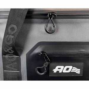 Close up of grey AO Coolers bag with black zipper pulls and branded strap