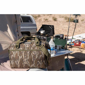 AO Coolers soft cooler in camouflage print sitting on a camping table