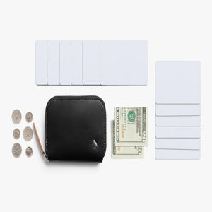 Bellroy black leather zip wallet with coins, paper currency, and multiple blank white cards