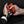 Hands holding an orange and black ActionHeat portable hand warmer