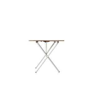 Side view of a folding table with a wooden top and white metal cross legs
