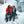 Couple wearing Baffin winter boots and heavy coats sitting on a rock in front of a frozen waterfall
