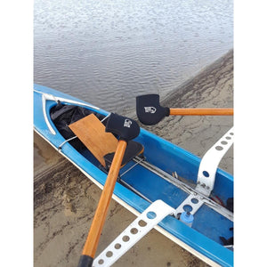 Bar Mitts covers on rowing oars in a blue rowing shell on a sandy shore