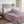 Person sitting on a bed covered by a purple Beautyrest heated blanket