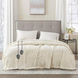 Beautyrest cream heated electric blanket with two remote controllers on a bed