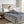 Person reading a book in bed under a grey Beautyrest heated blanket