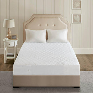 Beautyrest white quilted mattress pad on a bed with a beige tufted headboard