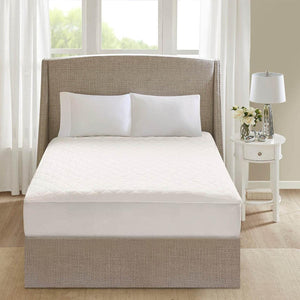 Beautyrest white quilted mattress pad on a bed with two pillows and a headboard