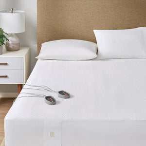 Beautyrest heated mattress pad with two wired controllers on a white bed