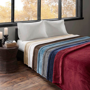 Beautyrest heated blankets in various colors layered on a bed
