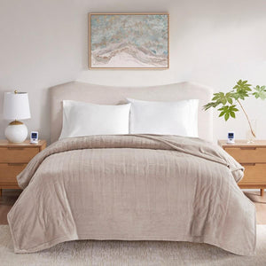 Beige textured blanket draped over a bed with white pillows and wooden nightstands