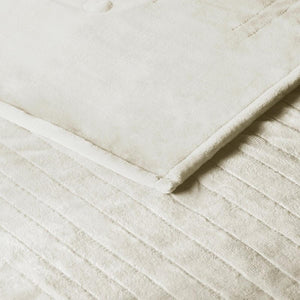 Close up of cream colored velvet textured bedding with channel stitching