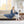 Woman sitting on a sofa reading a book while wrapped in a blue Beautyrest heated throw blanket