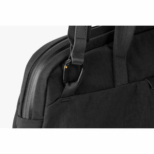 Close up of a black Bellroy bag showing the strap attachment and carabiner