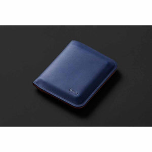 Blue Bellroy leather wallet on a dark background