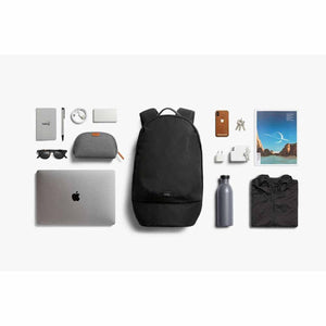 Bellroy black backpack surrounded by organized daily carry items including a laptop, water bottle, and accessories