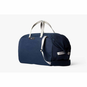 Bellroy navy blue duffel bag with light grey handles and shoulder strap