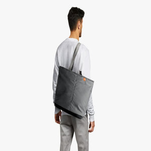 Person wearing a grey Bellroy tote bag over their shoulder