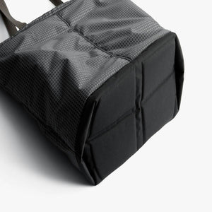 Base of a grey Bellroy tote bag with a grid pattern and reinforced black bottom panel