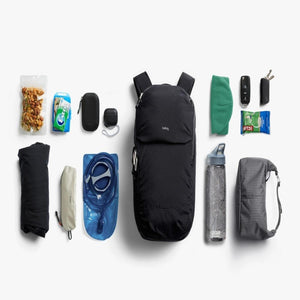 Bellroy backpack laid flat surrounded by organized hiking gear including water bladder, snacks, and accessories