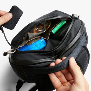 Open Bellroy bag showing internal compartments with snacks and a small blue container