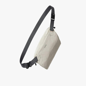Off white Bellroy sling bag with grey adjustable strap
