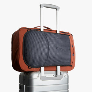 Bellroy travel bag attached to a silver rolling suitcase handle