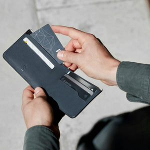 Hands removing a card from a Bellroy leather wallet