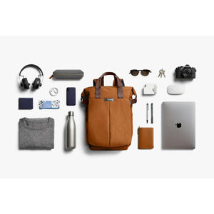 Bellroy backpack surrounded by organized daily carry items including laptop camera headphones and accessories