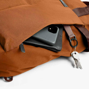 Bellroy backpack pocket containing a phone and wallet with a key clip attached to the exterior