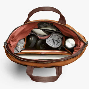 Top view of open Bellroy bag filled with laptop, water bottle, and personal accessories