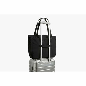 Bellroy black tote bag attached to a silver luggage handle