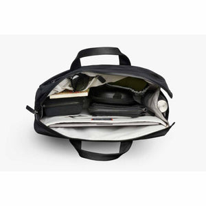 Top view of open black Bellroy briefcase filled with laptop and various accessories