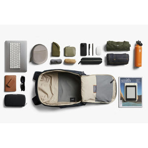 Bellroy backpack laid flat with organized travel accessories and personal items arranged around it