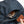 Hand opening a zippered pocket on a blue Bellroy backpack containing a wallet and pens