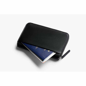 Bellroy black leather travel wallet with a passport tucked into the exterior pocket