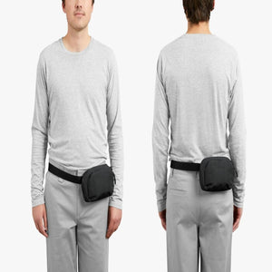 Bellroy black sling bag worn on the front and back of a person