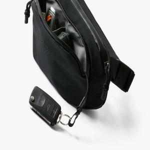 Bellroy black sling bag with internal pockets and key fob attached to car key