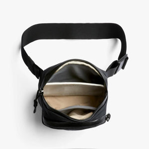 Open interior of black Bellroy Venture sling bag showing internal pockets and strap