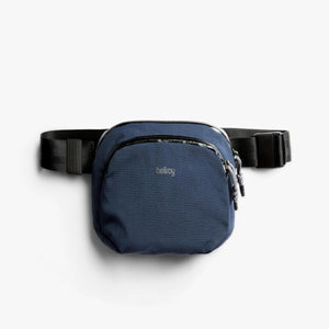 Navy blue Bellroy sling bag with black adjustable strap and zipper closure