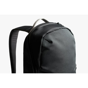 Close up of the top handle and shoulder strap of a black Bellroy backpack