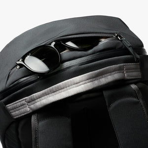 Black Bellroy backpack with sunglasses stored in the top zippered pocket
