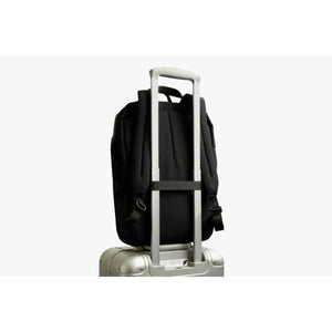 Bellroy black backpack secured to a silver luggage handle