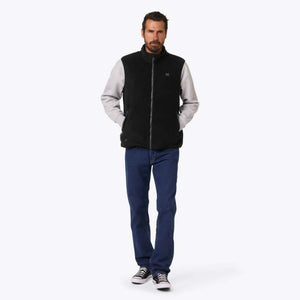 Man wearing a black Mobile Warming fleece vest over a grey long sleeve shirt and blue jeans